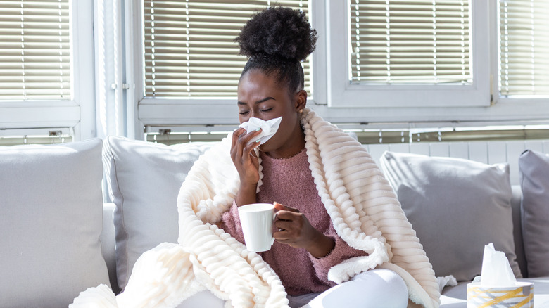 Black woman with cold blowing nose