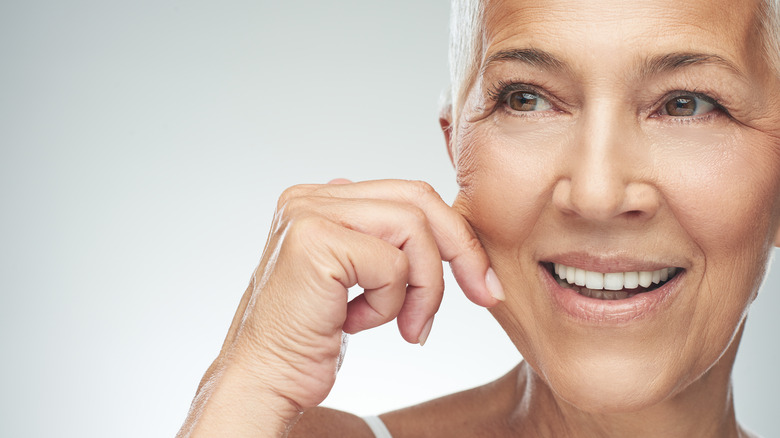 older woman pinching her cheek