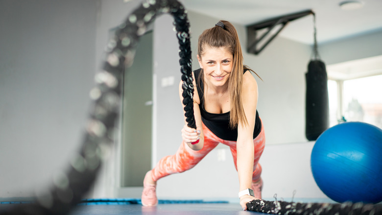 woman doing plank pull with battle rope