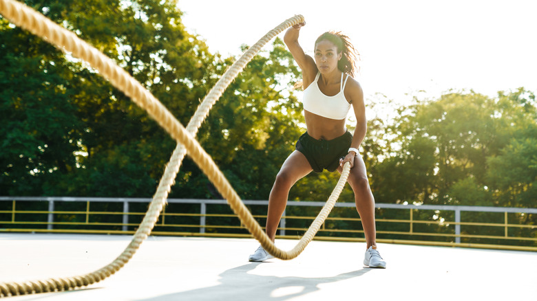 woman using battle ropes