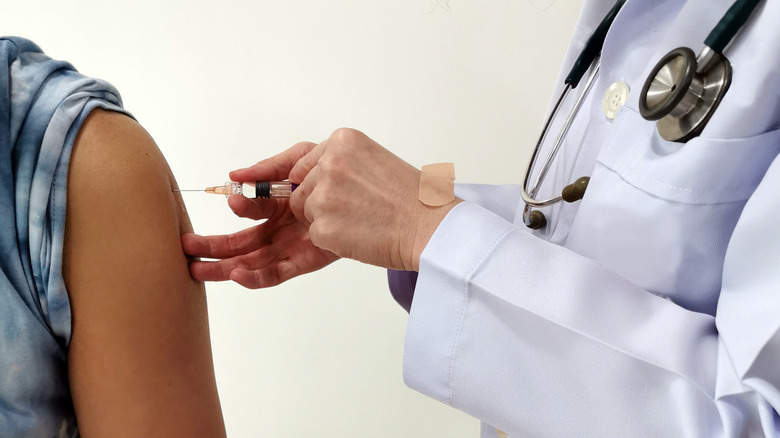 doctor administering vaccine on arm