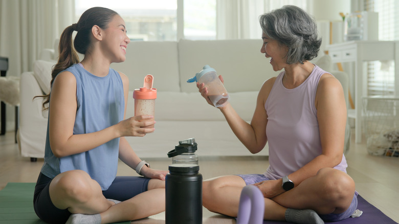 young woman and mother drinking protein shakes