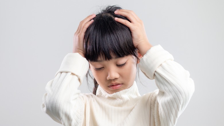 girl holding her head