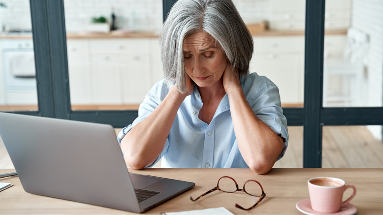 An older woman suffers from pain