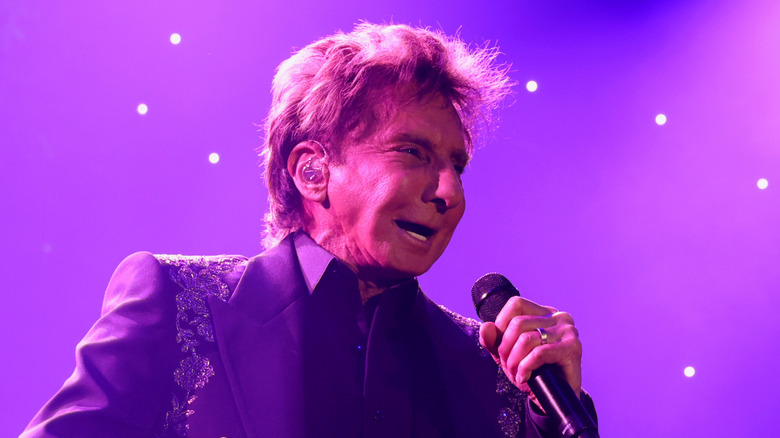 Barry Manilow performs on stage in 2025