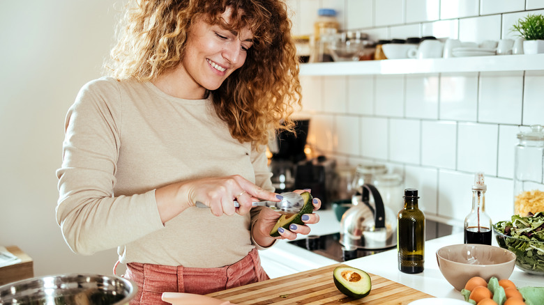 woman cutting open an avocado