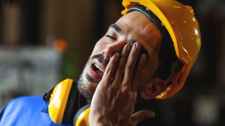 Construction worker holding eye