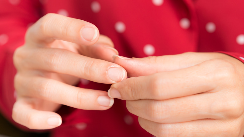 Hands examining fingernails