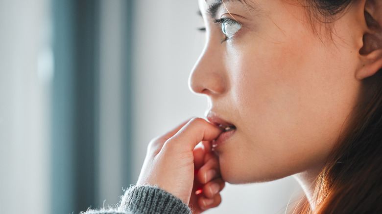 Woman biting her thumbnail