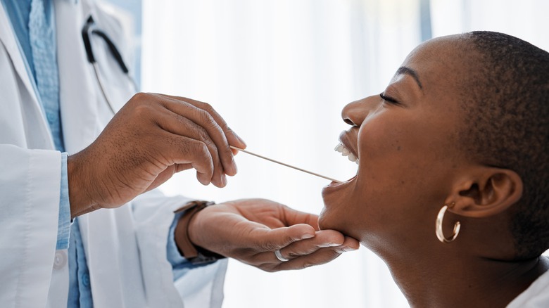 doctor examining patient's tonsils