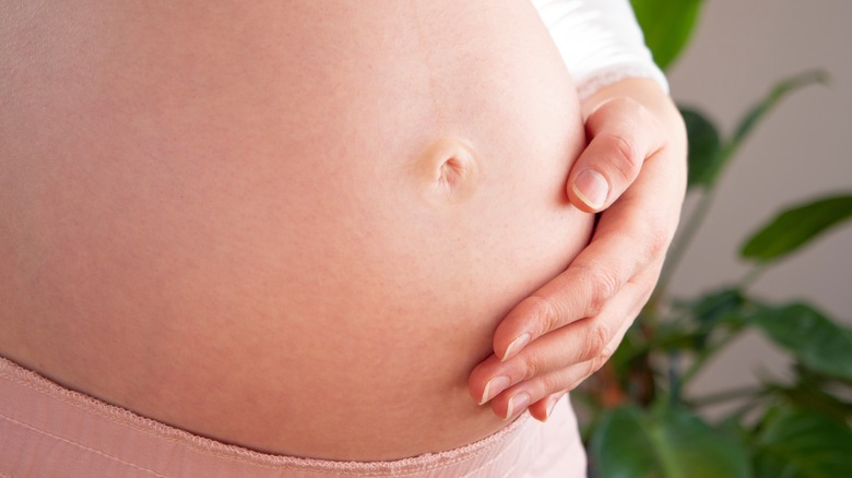 Hand cupping pregnant belly