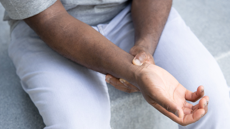 Hand clutching wrist in pain