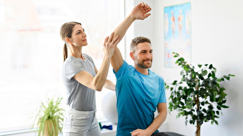 physical therapist working with a man's shoulder