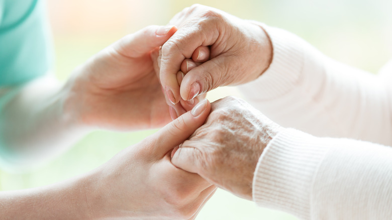 close-up of a caregiver and patient's hands