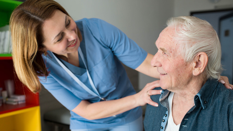 nurse tending to older man with Parkinson's