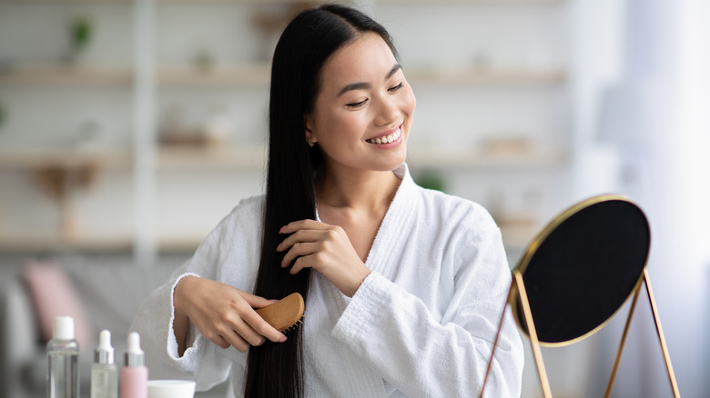 woman sits brushing hair 
