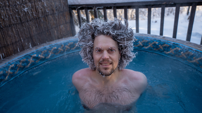 man in outdoor hot tub during winter
