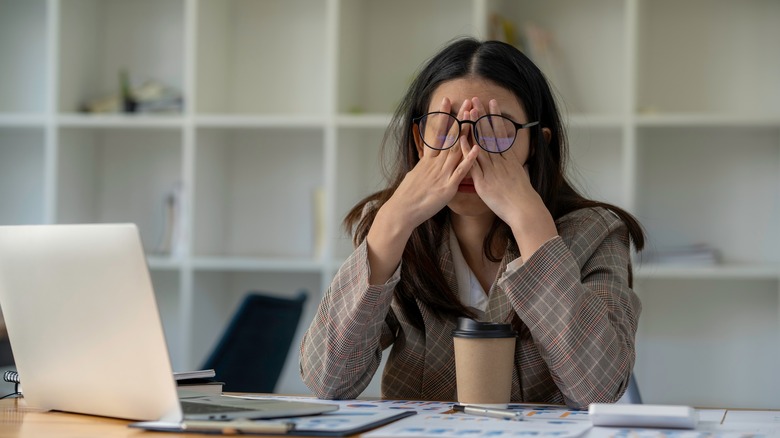 woman rubbing blurry eyes