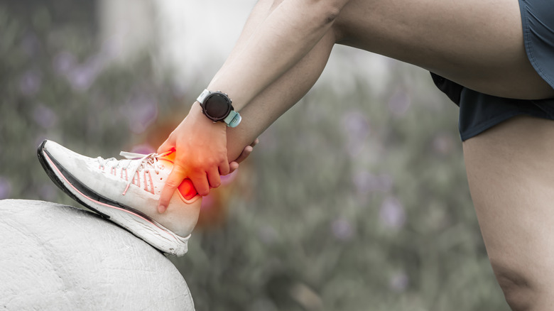 woman holding painful Achilles tendon