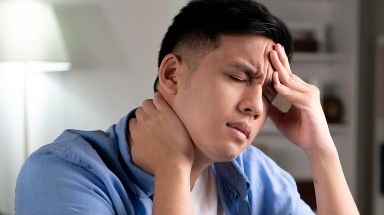 Man with headache touching forehead