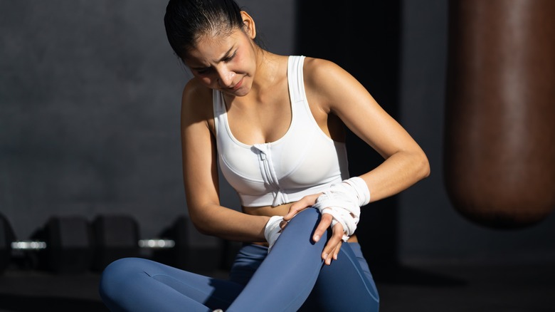 fit woman tending to her knee pain