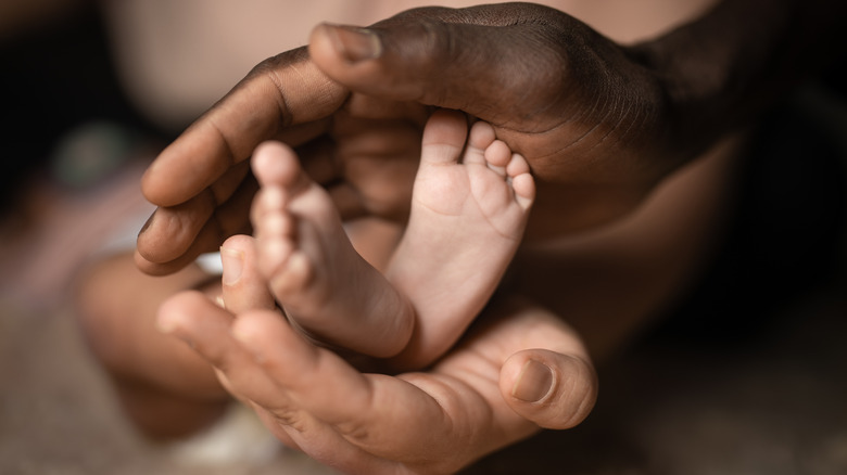 Adult hands holding baby feet