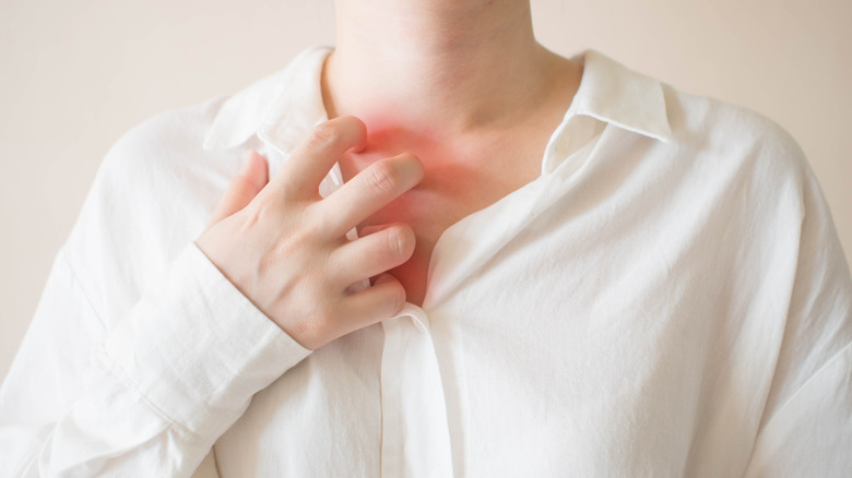 Close up of hand itching neck