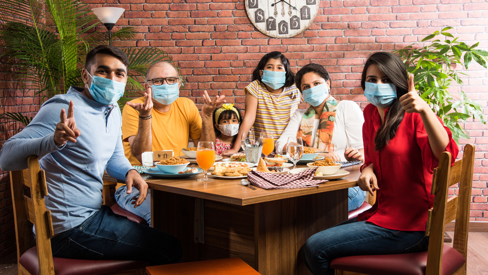 Family in restaurant wearing face masks