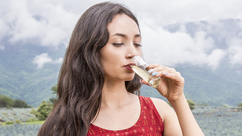 woman drinking shot of tequila