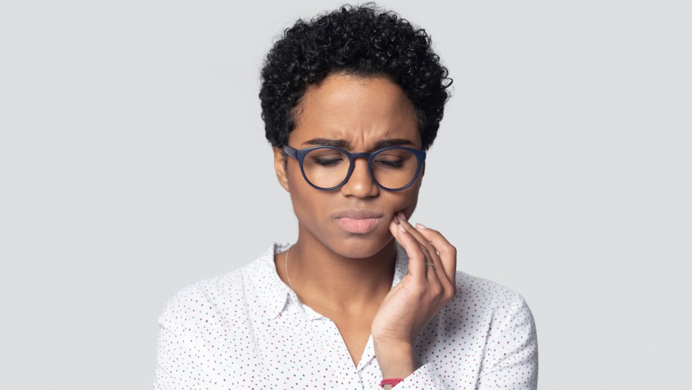 woman with tooth pain from apple cider vinegar