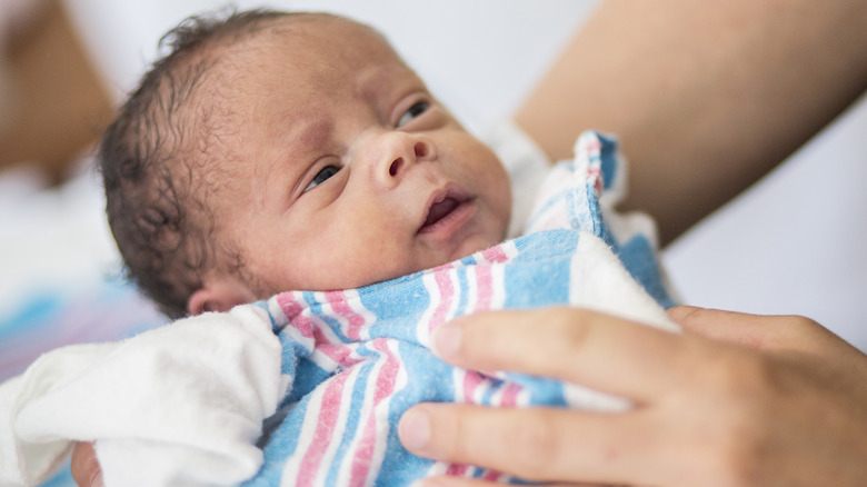 Newborn baby being held