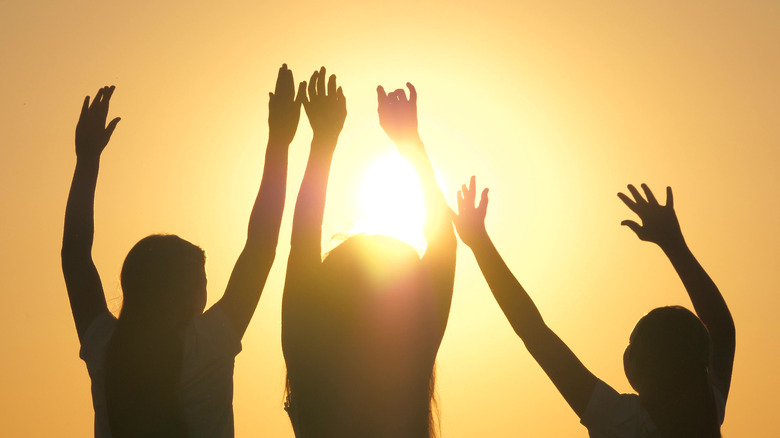 Silhouette of young people dancing in the sun