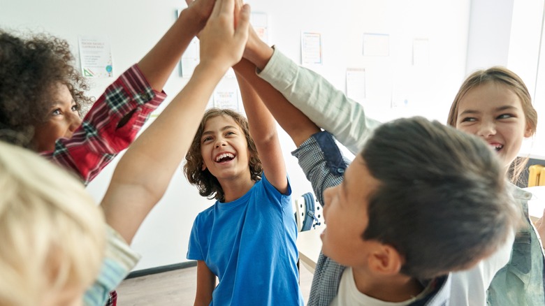 a group of children high fiving each other