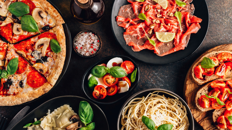 A table full of foods containing tomatoes