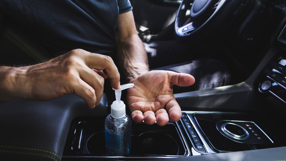 Man using hand sanitizer in car