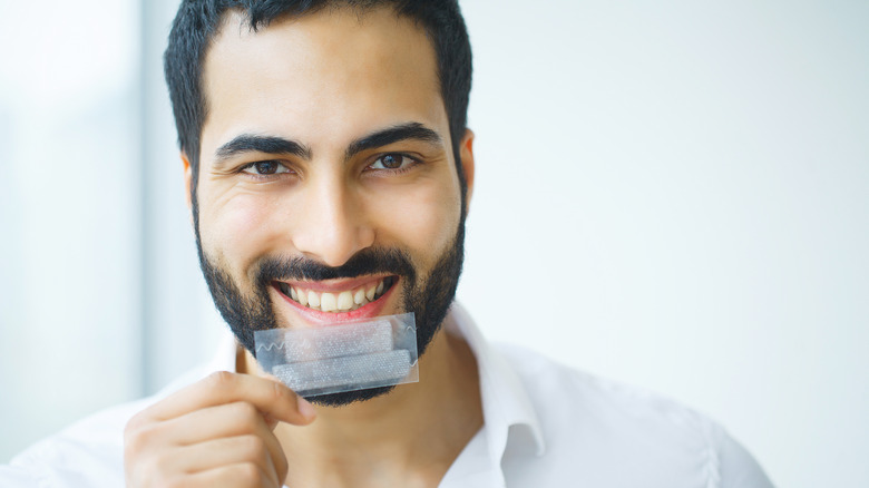 Man holding teeth whitening strips