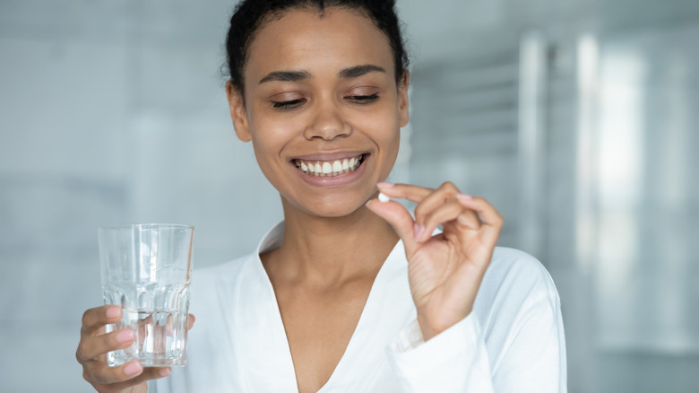 A woman takes a supplement