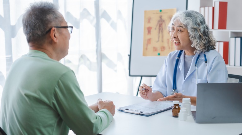Man talking to smiling doctor