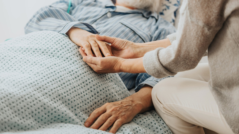 Elderly couple holding hands 