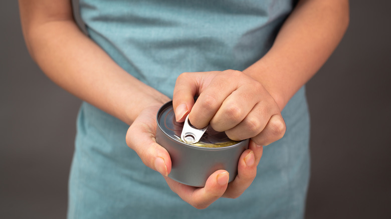 Woman opening canned tuna