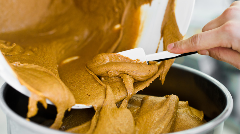 Someone putting peanut butter in bowl
