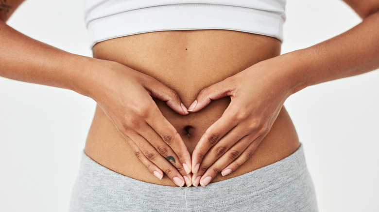 Woman with hands on navel