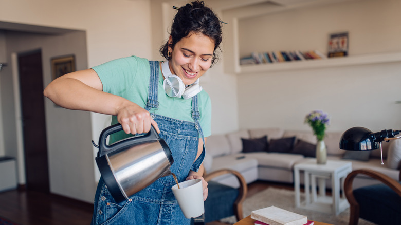 Smiling woman pouring cup of coffee