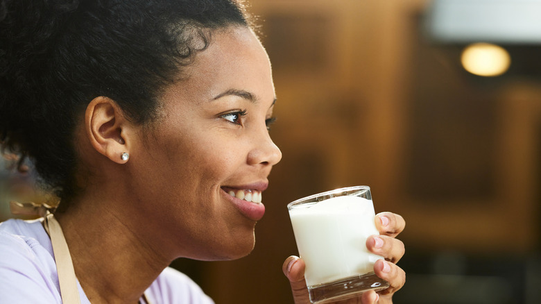 woman drinking small glass of milk