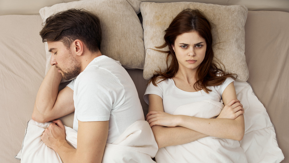 Couple in bed, woman is angry