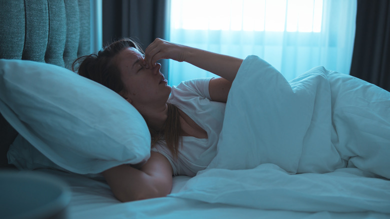 A woman lying awake in bed having a hard time sleeping