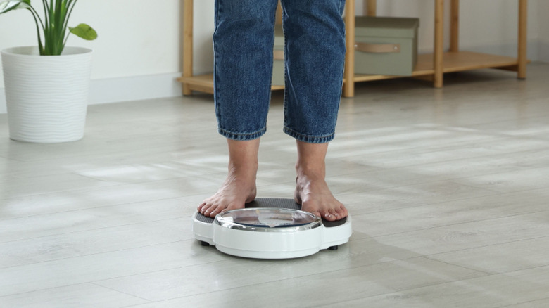 A woman standing on a weighing scale