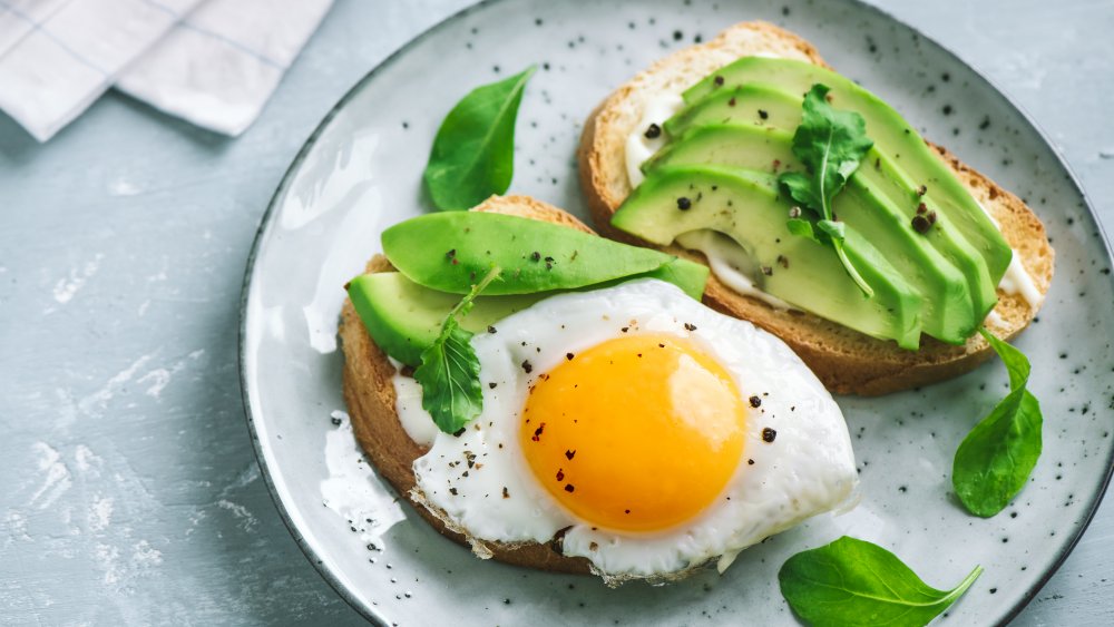 Sliced avocado on toast with a fried egg