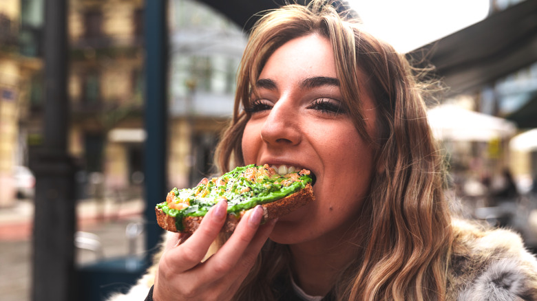 Woman eating avocado on toast