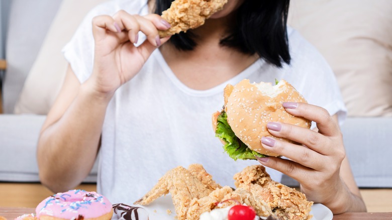 Woman consuming excessive amounts of junk food